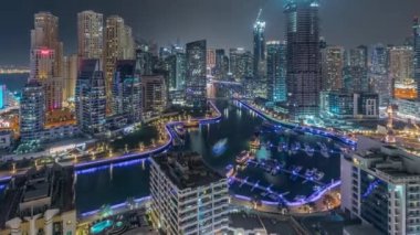 Dubai Marina 'da limana park etmiş birkaç tekne ve yatları ve kanalın etrafında gökdelenleri var..