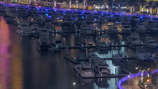 Muchos yates y barcos están aparcados en el timelapse noche aérea del puerto en Dubai Marina — Vídeo de stock