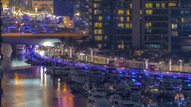 Many yachts and boats are parked in harbor aerial night timelapse in Dubai Marina — Stock Video