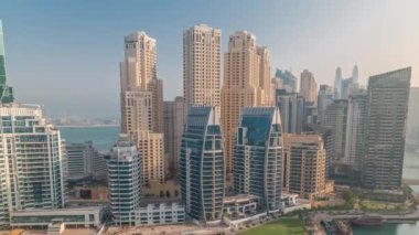 Dubai Marina 'da limana park etmiş çok sayıda tekne ve yat ve kanalın etrafında gökdelenler var..
