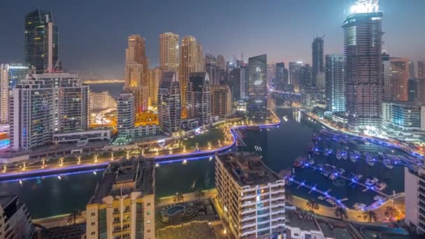 Dubai Marina con diverse barche e yacht parcheggiati in porto e grattacieli intorno canale aereo notte al giorno timelapse. — Video Stock