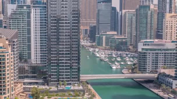 Dubai Marina con diverse barche e yacht parcheggiati in porto e grattacieli intorno timelapse aerea canale. — Video Stock