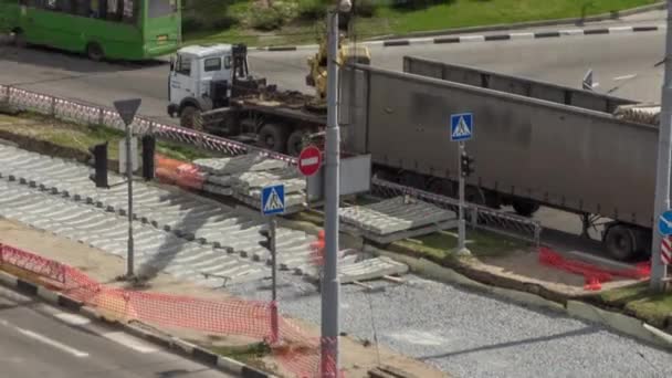 Loader crane for loading and unloading sleepers from truck which stands on a road construction site aerial timelapse — Stockvideo