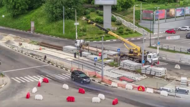Laadkraan voor het laden en lossen van betonnen platen van een vrachtwagen die op een bouwplaats in de lucht staat — Stockvideo