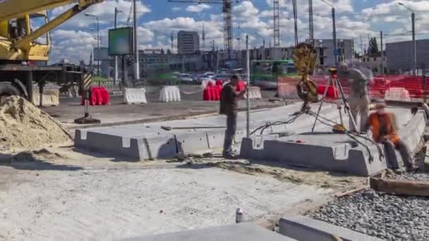 Installera betong plattor av crane på vägen konstruktion webbplats timelapse. — Stockvideo