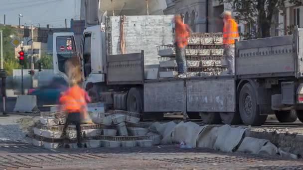 Grue chargeuse pour le chargement et le déchargement des traverses de camion qui se trouve sur un chantier de construction routière timelapse aérienne — Video