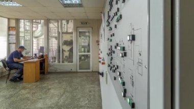 Fabrika denetim masası timelapse hyperlapse. Kontrol odası ve iterek düğmeleri ve anahtarları kontrol panelinde önünde duran mühendisi