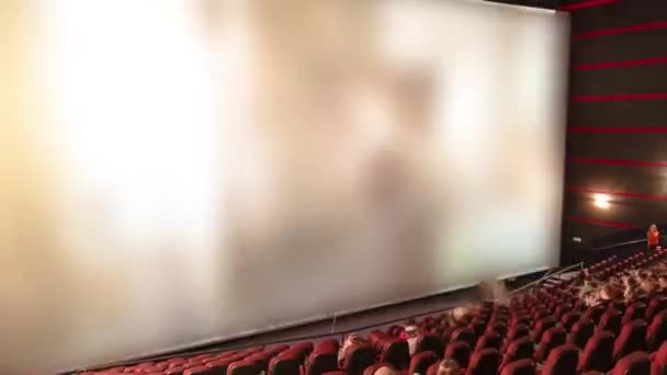Зрители смотрят кино в кинотеатре по прошествии времени — стоковое видео