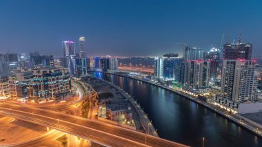 Business Bay hava sahasındaki gökdelenler ve kuleler Dubai, Birleşik Arap Emirlikleri 'ndeki gece gündüz geçiş zamanları. Gün batımından sonra yukarıdan panoramik görüntü