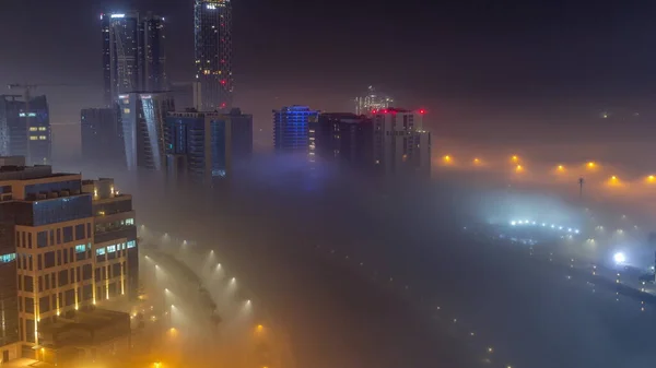 商业湾的建筑物被浓雾笼罩 夜幕降临 水渠周围明亮的摩天大楼 鸟瞰全景 — 图库照片