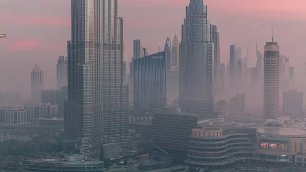 霧の夜から日への移行時間経過中のドバイ市内早朝の空中ビュー 高層ビルや高層ビルが立ち並ぶ未来的な都市スカイライン — ストック写真