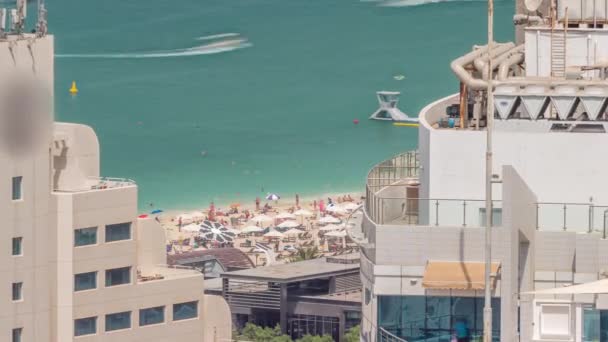 Crowded JBR beach with tourists enjoying the sun and the sea, sitting under umbrellas aerial top view from above timelapse — Stock Video