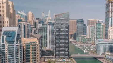 Dubai Marina 'da limana park etmiş çok sayıda tekne ve yat ve kanalın etrafında gökdelenler var..