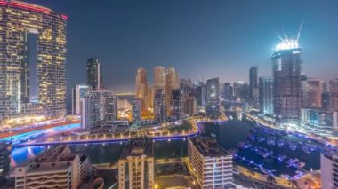 Dubai Marina 'da limana park etmiş bir sürü tekne ve yat ve gökdelenler gece gündüz kanal antenleri etrafında..