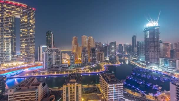 Dubai Marina con diverse barche e yacht parcheggiati in porto e grattacieli intorno canale aereo notte al giorno timelapse. — Video Stock