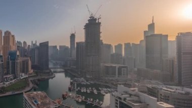 Dubai Marina 'da limana park etmiş bir sürü tekne ve yat ve kanalın etrafında gökdelenler var..