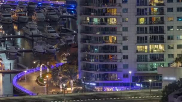 Muchos yates y barcos están aparcados en el timelapse noche aérea del puerto en Dubai Marina — Vídeo de stock