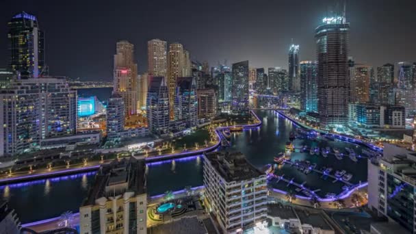 Panorama che mostra Dubai Marina con diverse barche e yacht parcheggiati in porto e grattacieli intorno al canale aereo notte timelapse. — Video Stock