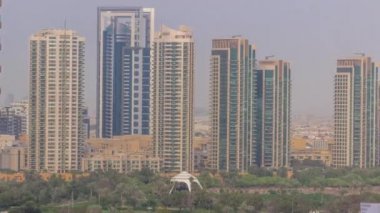 Dubai marinasından yeşil bölgedeki kulelerin hava görüntüsü..