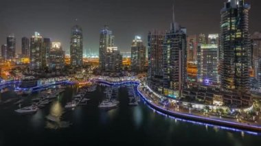 Şehirde lüks yat körfezi Dubai marinasında havadan gece saatleri.