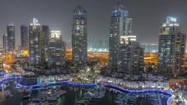 Şehirde lüks yat körfezi Dubai marinasında havadan gece saatleri.