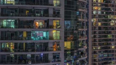 Çok katlı binaların pencerelerinde düz gece panoramasında çok renkli ışık var..