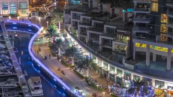 Waterfront promenade with palms in Dubai Marina aerial night timelapse. — Stockvideo