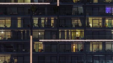 Çok katlı binaların pencerelerinde düz gece panoramasında çok renkli ışık var..