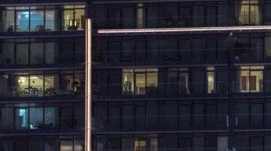 Çok katlı binaların pencerelerinde düz gece panoramasında çok renkli ışık var..