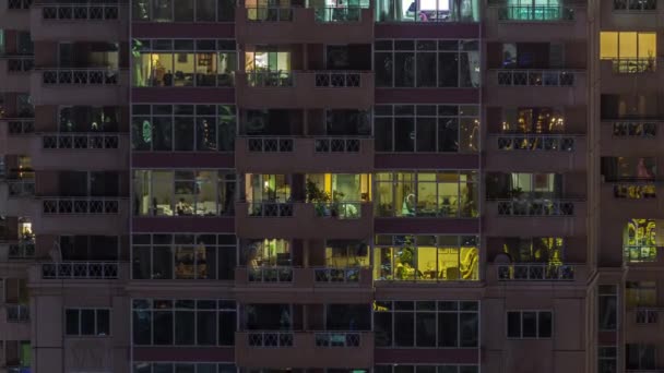 Panorama nocturno plano de luz multicolor en ventanas de edificios de varios pisos timelapse aéreo. — Vídeo de stock