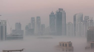 Dubai gökdelenleri, sabah sisi ile birlikte gece gündüz geçiş zamanı. Birleşik Arap Emirlikleri 'nin şehir merkezinden hava görüntüsü.