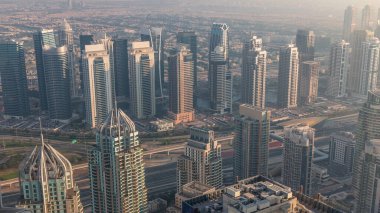 Şeyh Zayed Yolu yakınlarındaki JLT ve Dubai marina gökdelenleri. Arkasında konut binaları ve villalar var. Sisli hava
