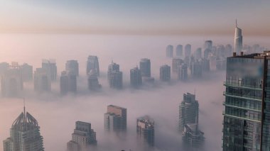 Güneş doğduktan sonra Şeyh Zayed Yolu yakınlarındaki JLT gökdelenleri ve marina kulelerini sis kapladı. Konut binası sisli bir sabah ve sıcak turuncu ışık