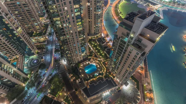 迪拜市中心的摩天大楼俯瞰着夜晚空中的美景 塔楼和游泳池之间的道路上交通明亮的房屋 — 图库照片