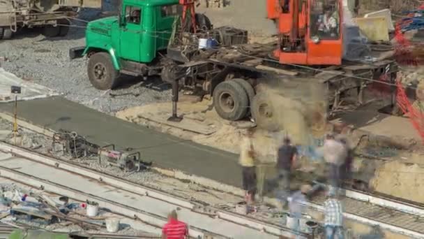 Betongarbeten för vägkonstruktion med många arbetare och mixer timelapse — Stockvideo
