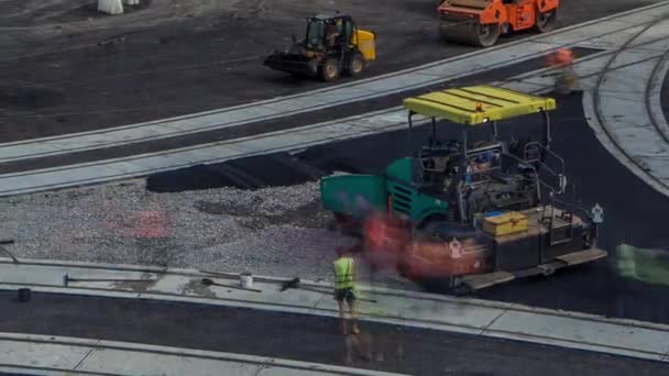 Asphalt paver, roller and truck on the road repair site during asphalting timelapse. Road construction equipment. — Stock Video