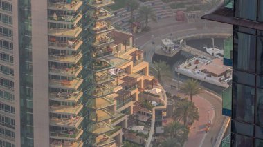 Dubai Marina rıhtımında gezinti zamanı, Dubai, BAE. Gökdelenlerde birçok restoran ve pencere var.