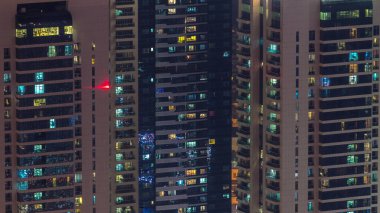 Gecenin ilerleyen saatlerinde gökdelenlerin dış tarafındaki pencereler zaman ayarında parıldıyor ve yanıp sönüyor. Havadan üst görünüm