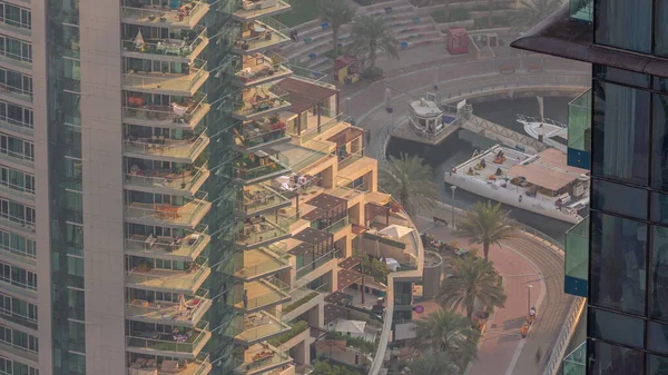 Dubai Marina rıhtımında gezinti zamanı, Dubai, BAE. Gökdelenlerde birçok restoran ve pencere var.