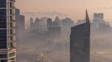 Dubai Havacılık, Dubai marinasından Al Barsha Tepeleri ve Yeşiller Bölgesi zaman çizelgesi üzerinde sis olduğunu gösteriyor. Kuleler ve gökdelenler Yukarıdan sisli bir sabah