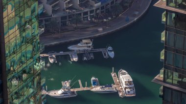 Dubai Marina Rıhtımı, gölgeli hava zaman ayarlı, Dubai, BAE. Gökdelenler arasında birçok restoran, yüzen yat ve tekne var.