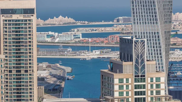 Dubai Marina 'daki gezinti güvertesi ve kanalı. Zaman çizelgesi etrafında lüks gökdelenler var. Birleşik Arap Emirlikleri. Yatlar ve tekneler yukarıdan Palm Island 'a kadar havadan görünüyor.