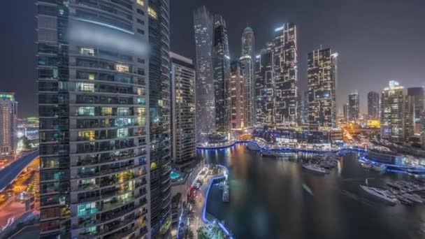 Dubai marina tallest skyscrapers and yachts in harbor aerial night timelapse. — Video Stock