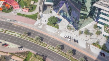 Dubai Uluslararası Finans Merkezi zaman diliminde bulunan ofis kulesine giriş. Dubais merkez finans bölgesinde restoranlar ve yol trafiği var.