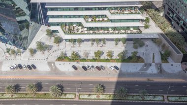 Ofis kulesi Dubai Uluslararası Finans Merkezi zaman diliminde yer almaktadır. Gölgeler hızlı hareket ediyor. Dubais merkez finans bölgesinde restoranlar ve yol trafiği var.