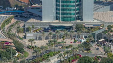 Dubai 'nin finans bölgesindeki kavşak kavşağı yolunun yukarıdan görünüşü. Sokakta trafik vardı, avuçlar gökdelenin girişine yakındı. Dubai, Birleşik Arap Emirlikleri.
