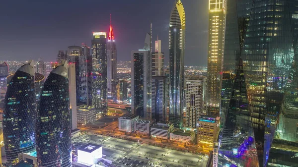 Dubai 'nin finans merkezi. Lüks gökdelenler, gece gündüz geçiş zamanları, Dubai, Birleşik Arap Emirlikleri. Otoparkı ve çatısı olan hava manzarası