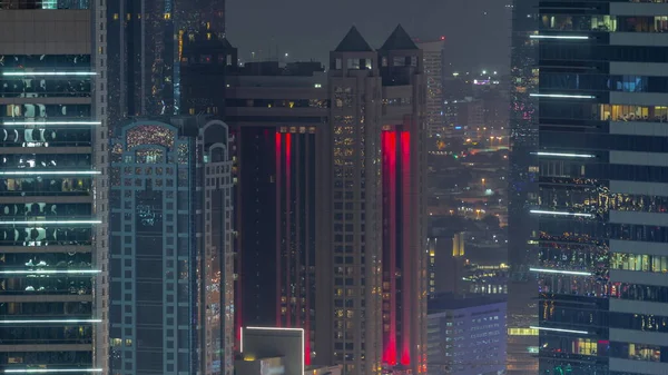 ガラス面の空中ビューで窓や塔を成長させます 照らさ豪華な高層ビルの夜のタイムラプスを持つドバイ市の金融センター ドバイ アラブ首長国連邦 — ストック写真