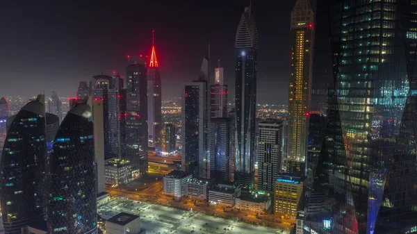 Dubai 'nin finans merkezi, tüm gece boyunca aydınlık lüks gökdelenler, Dubai, Birleşik Arap Emirlikleri. Otoparkı ve çatıları sisle kaplı olan gökyüzü manzarası. Işıklar kapanıyor.