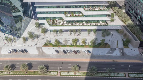 Ofis kulesi Dubai Uluslararası Finans Merkezi zaman diliminde yer almaktadır. Gölgeler hızlı hareket ediyor. Dubais merkez finans bölgesinde restoranlar ve yol trafiği var.